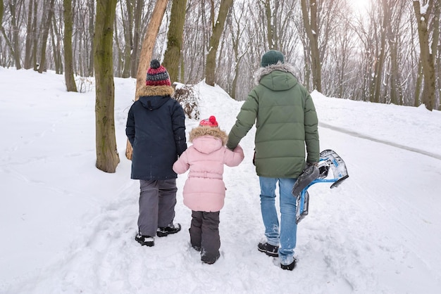 Familia feliz caminando en el parque de invierno Estilo de vida activo