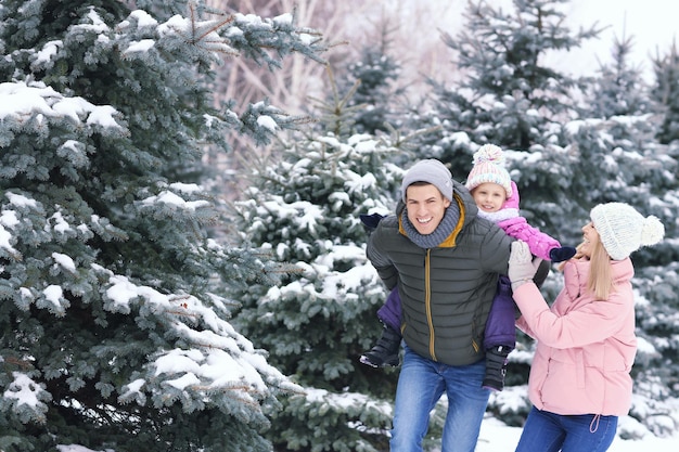 Familia feliz caminando en el parque de invierno