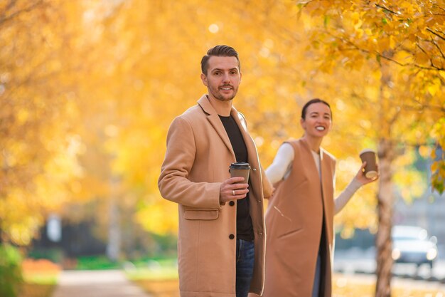 Familia feliz caminando en el parque de otoño en un día soleado de otoño