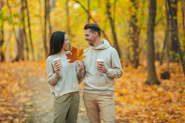 Familia feliz caminando en el parque de otoño en un día soleado de otoño