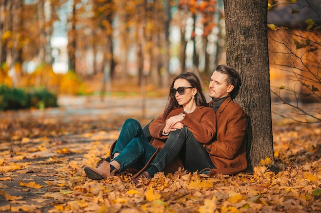 Familia feliz caminando en el parque de otoño en un día soleado de otoño