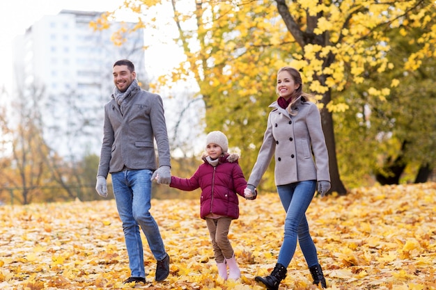 familia feliz caminando en el parque de otoño