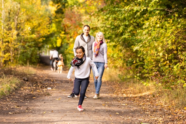 familia feliz caminando en el parque de otoño