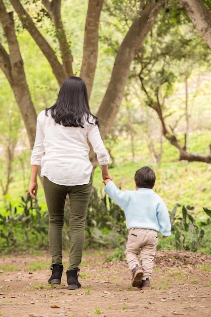 Familia feliz caminando por el parque por la tarde tomados de la mano