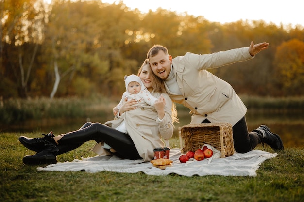 Família feliz caminhada no outono no parque. A criança, mãe, pai estão se divertindo no parque. Família