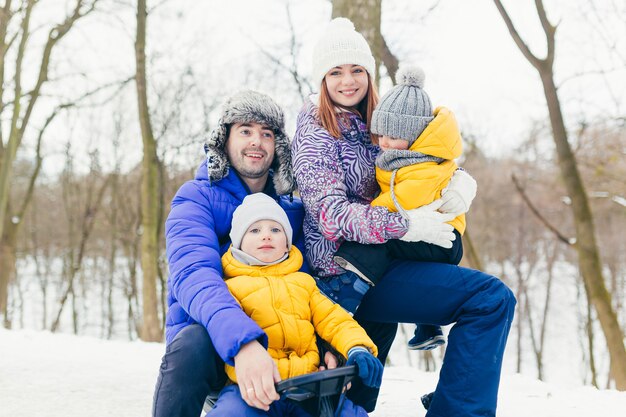 Família feliz caminhando juntos no parque de inverno, dois adultos, homem, mulher e dois filhos