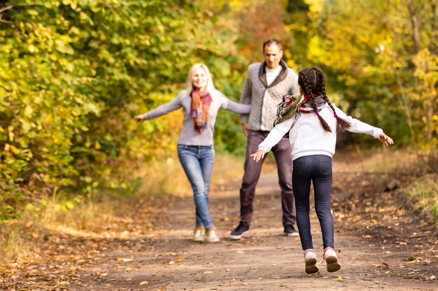 família feliz caminhando no parque de outono