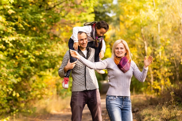 família feliz caminhando no parque de outono