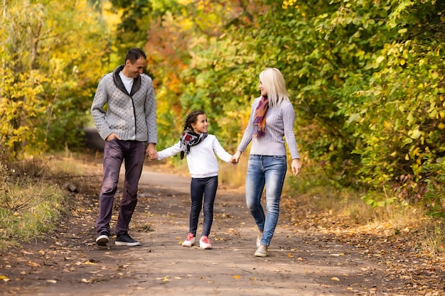 Família feliz caminhando pelo parque de outono