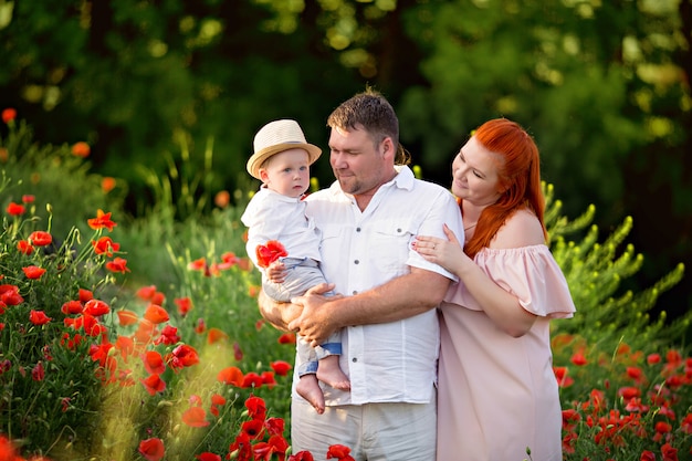 Familia feliz en un campo de amapolas en flor