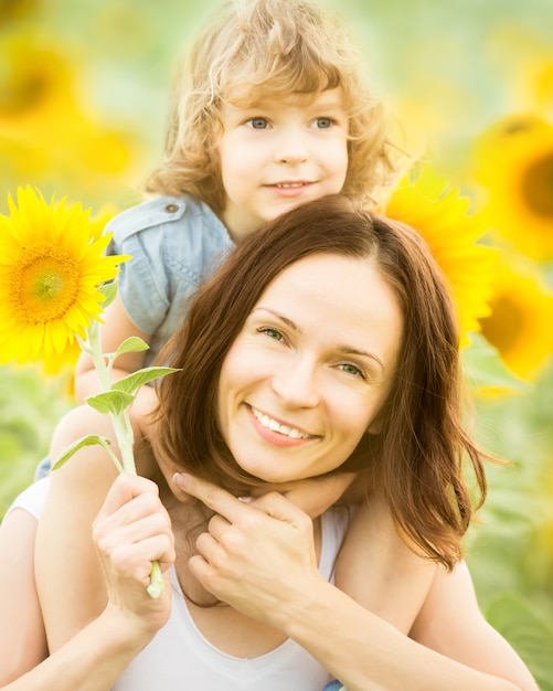 Familia feliz en campo de primavera de hermosos girasoles