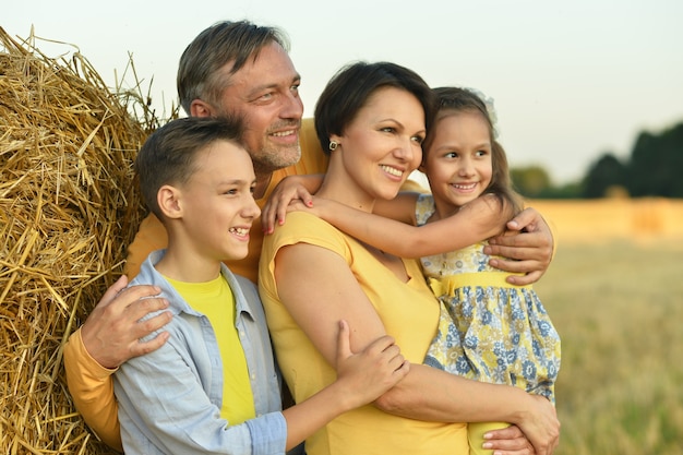 Foto familia feliz en campo de trigo en día soleado