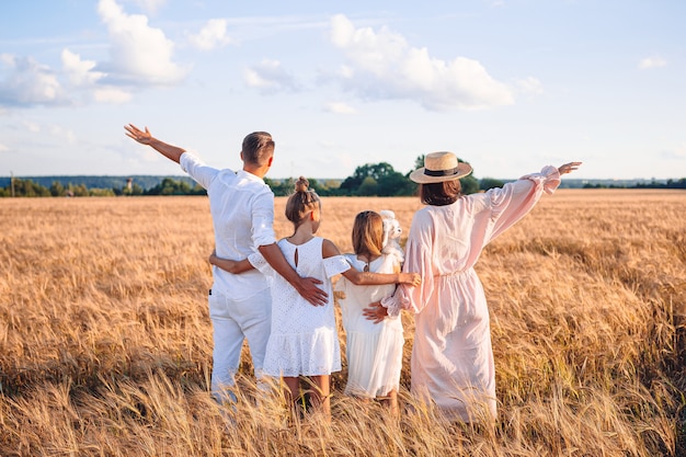 Familia feliz en un campo de trigo