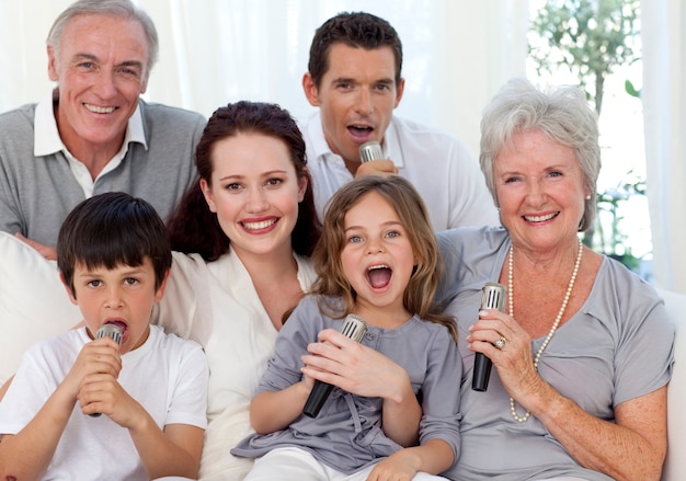 Familia feliz cantando karaoke en la sala de estar