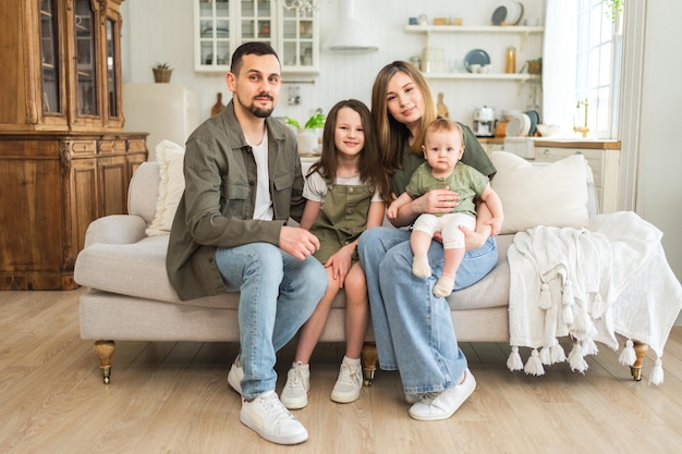 Familia feliz en casa madre padre dos hijos hijas relajándose en el sofá interior madre padre padres