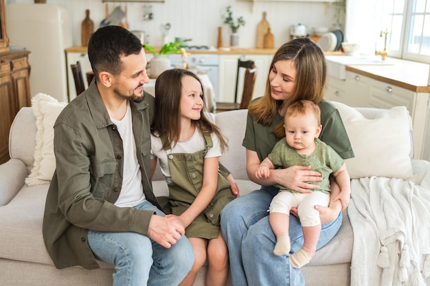 Foto familia feliz en casa madre padre dos hijos hijas relajándose en el sofá interior madre padre padres