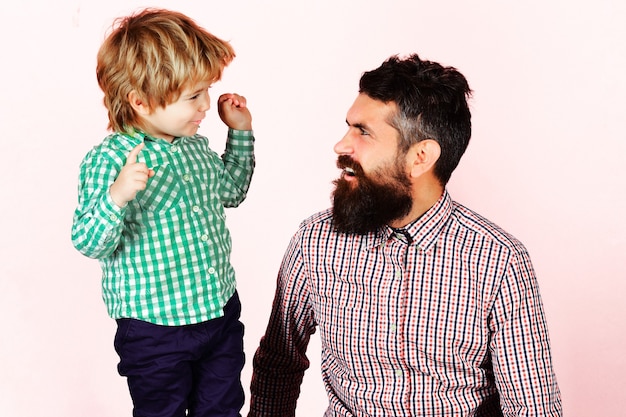 Familia feliz. Celebración del día del padre. Padre e hijo en camisas a cuadros mirando el uno al otro. Crianza de los hijos.