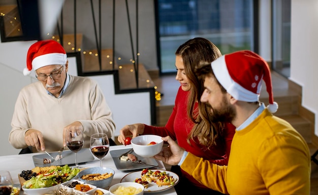 Familia feliz celebrando el año nuevo en la mesa en casa