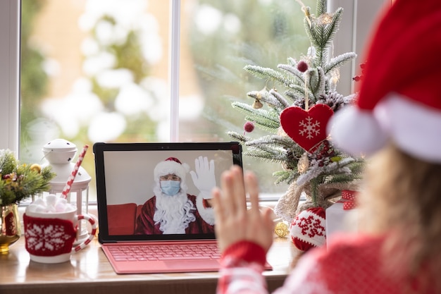 Familia feliz celebrando las vacaciones de Navidad en línea por chat de video en cuarentena. Concepto de estancia en casa de bloqueo. Fiesta navideña durante la pandemia de coronavirus COVID 19