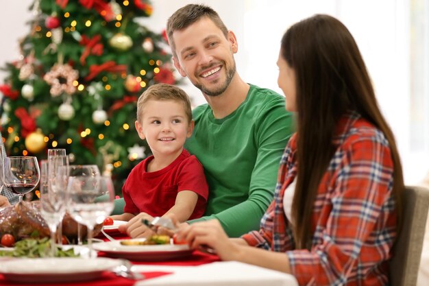 Familia feliz cenando en casa de Navidad