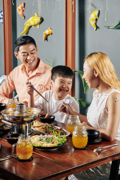 Familia feliz cenando en el restaurante