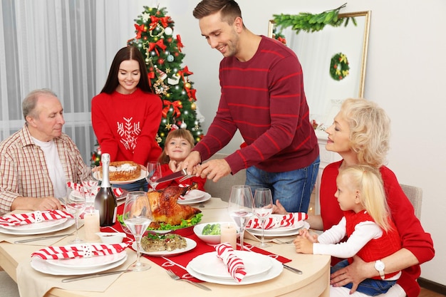 Familia feliz cenando en la sala de Navidad