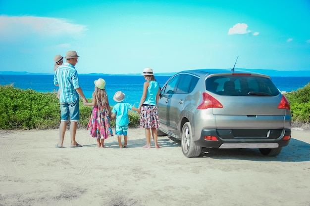 Una familia feliz en coche junto al mar en la naturaleza viaje de fin de semana