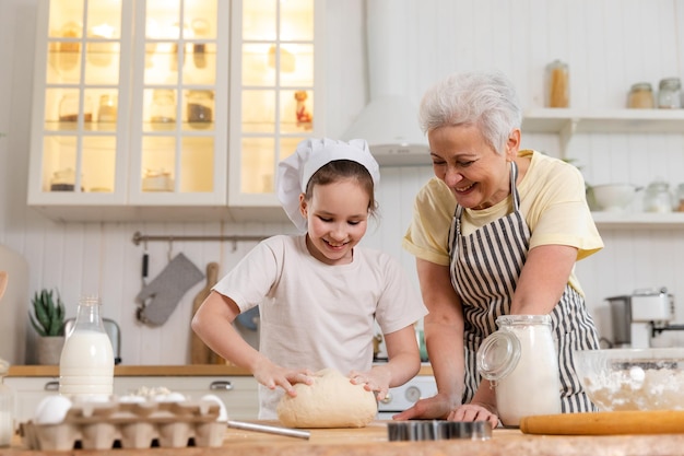 Familia feliz en la cocina abuela y nieta niño cocinar en la cocina juntos abuela enseñando