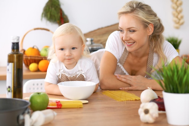 Familia feliz en la cocina. Hija de madre e hijo cocinando un delicioso desayuno