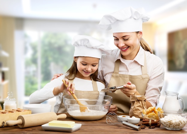 familia feliz en la cocina. madre e hija preparando la masa, hornear galletas