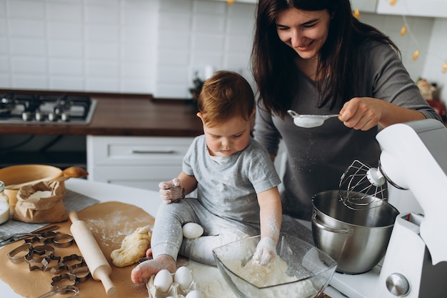 Familia feliz en la cocina. madre e hijo preparando la masa, hornear galletas