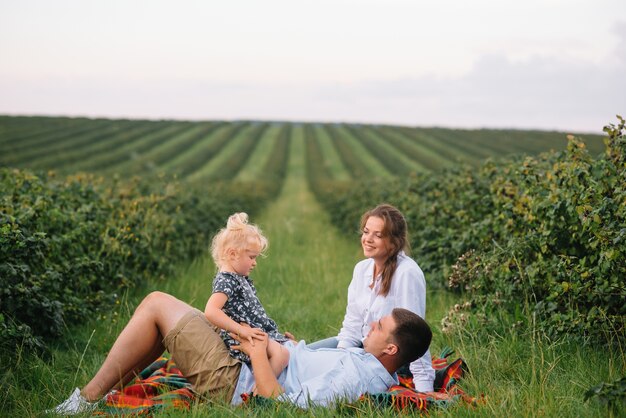 Família feliz com a filha passando um tempo juntos no campo ensolarado