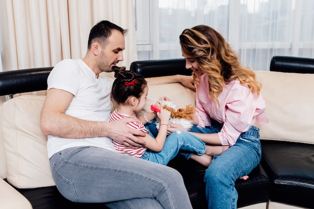 Família feliz com a filha se divertindo em casa. férias de verão.