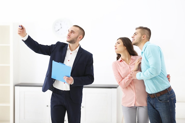 Família feliz com agente imobiliário na luz de fundo