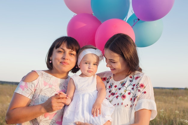 Família feliz com balões ao ar livre