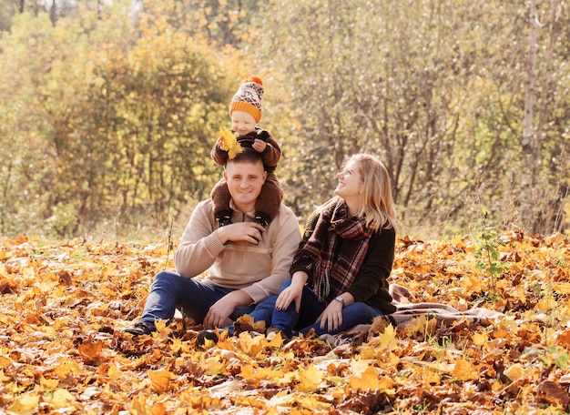 Família feliz com bebê no parque outono