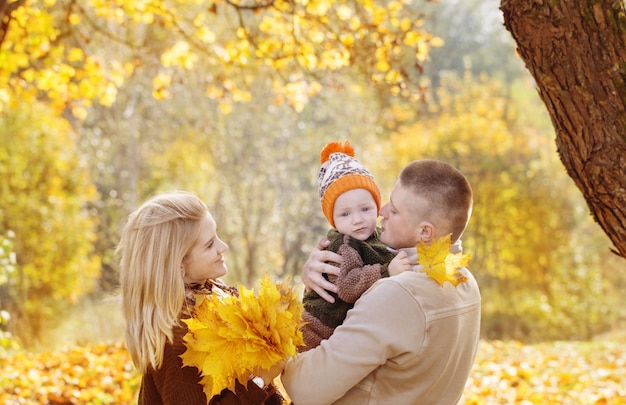 Família feliz com bebezinho no parque outono