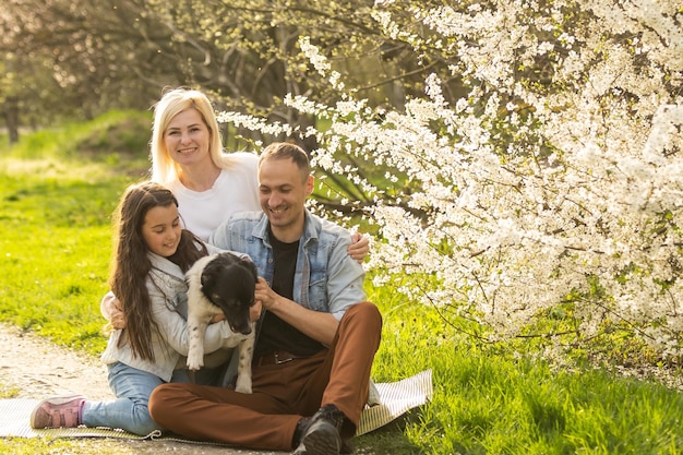 Família feliz com cachorro no jardim.