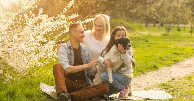 Família feliz com cachorro no jardim.