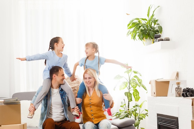 Família feliz com caixas de papelão na casa nova no dia da mudança.