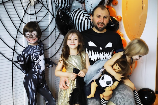 Família feliz com crianças em fantasias e maquiagem em uma celebração do halloween