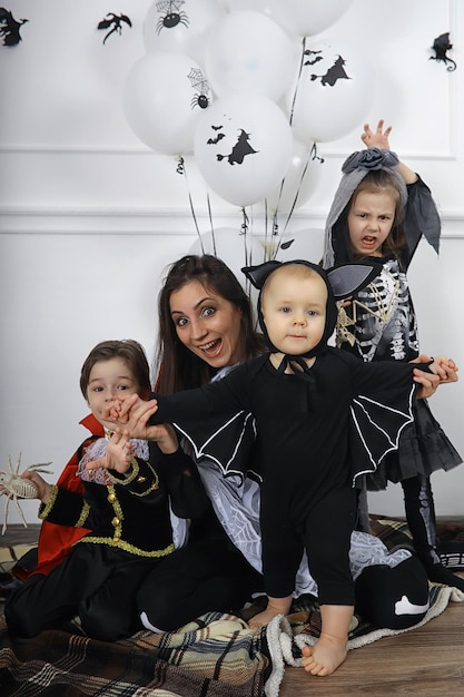 Foto família feliz com crianças fantasiadas de bruxa e vampiro em uma casa no feriado de halloween