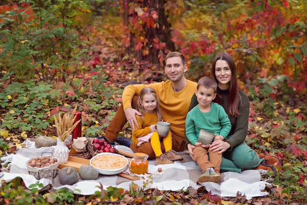 Família feliz com crianças fazendo piquenique na natureza