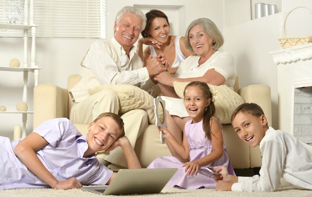 Família feliz com crianças no sofá na sala com laptop