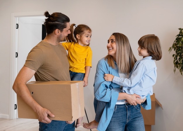 Foto família feliz com crianças se movendo em sua nova casa