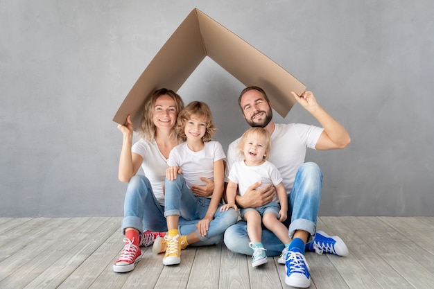 Família feliz com dois filhos brincando na nova casa