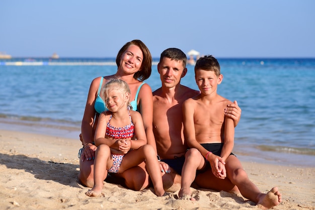 Família feliz, com dois filhos na praia