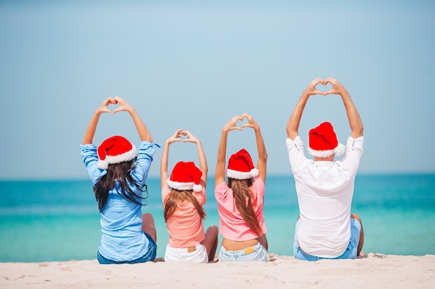 Família feliz com dois filhos no chapéu do Papai Noel nas férias de verão