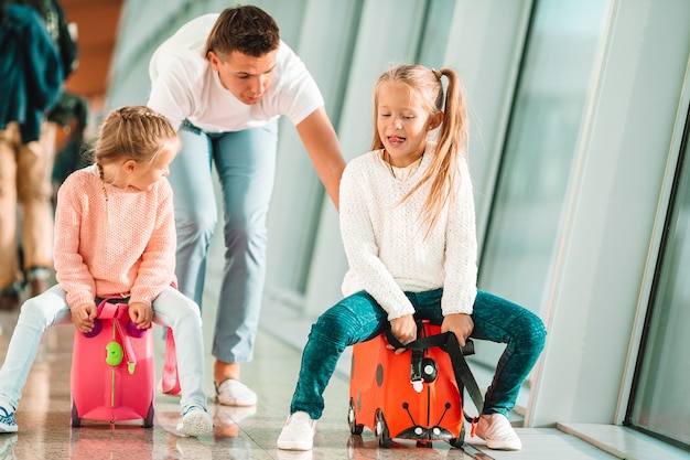 Foto família feliz com duas crianças no aeroporto se divertir à espera de embarque