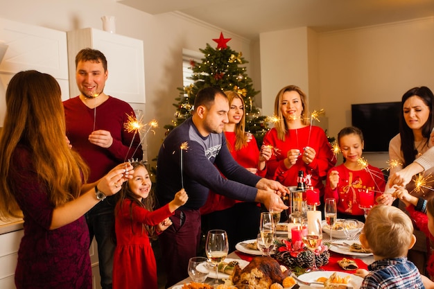 Família feliz com estrelinhas se divertindo no jantar em casa. Feliz Natal e Feliz Ano Novo